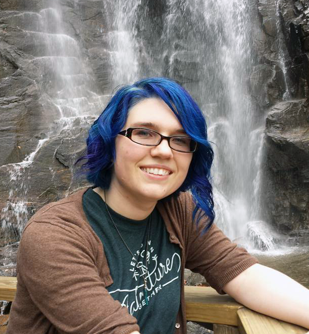 Emilie Nouveau with blue hair in front of waterfall